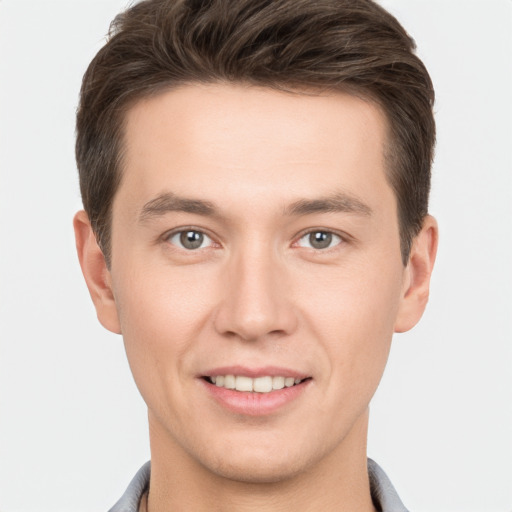 Joyful white young-adult male with short  brown hair and grey eyes