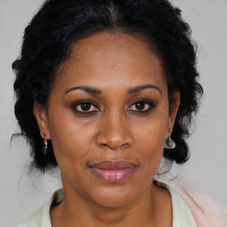 Joyful latino adult female with medium  brown hair and brown eyes