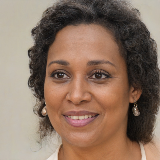 Joyful black adult female with medium  brown hair and brown eyes