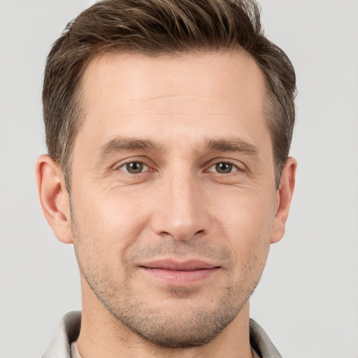 Joyful white young-adult male with short  brown hair and grey eyes