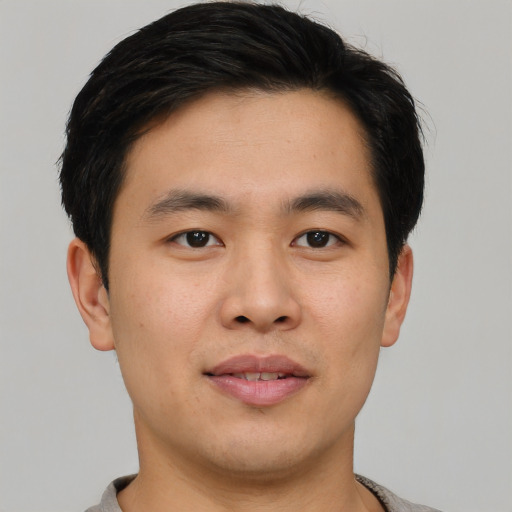Joyful asian young-adult male with short  brown hair and brown eyes