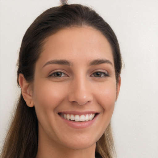 Joyful white young-adult female with long  brown hair and brown eyes