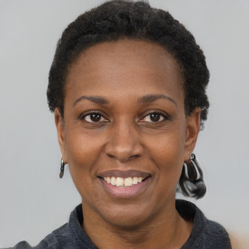 Joyful black adult female with short  black hair and brown eyes