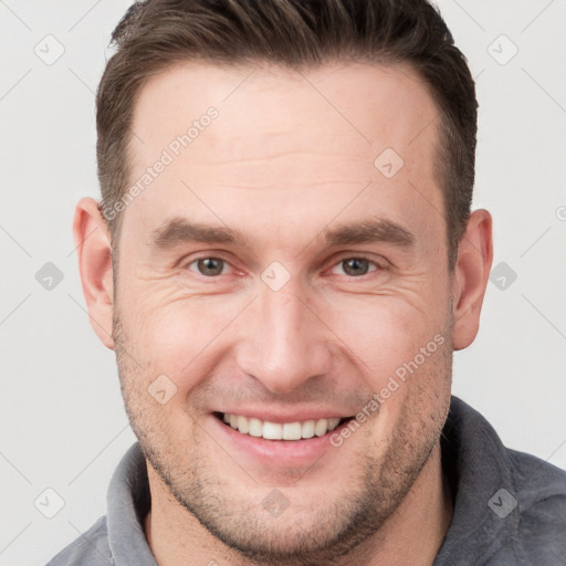 Joyful white adult male with short  brown hair and grey eyes