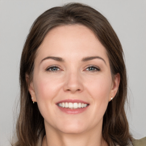 Joyful white young-adult female with medium  brown hair and grey eyes