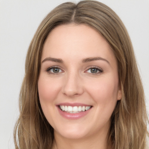 Joyful white young-adult female with long  brown hair and green eyes