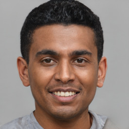 Joyful latino young-adult male with short  black hair and brown eyes