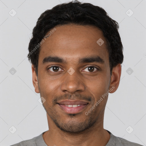 Joyful black young-adult male with short  black hair and brown eyes