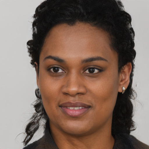 Joyful black young-adult female with long  black hair and brown eyes