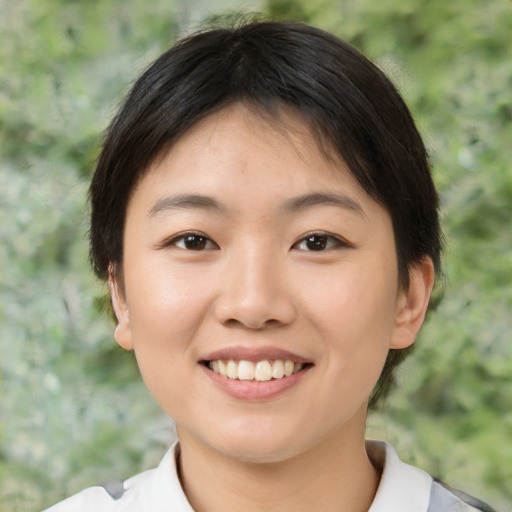 Joyful asian young-adult female with short  brown hair and brown eyes