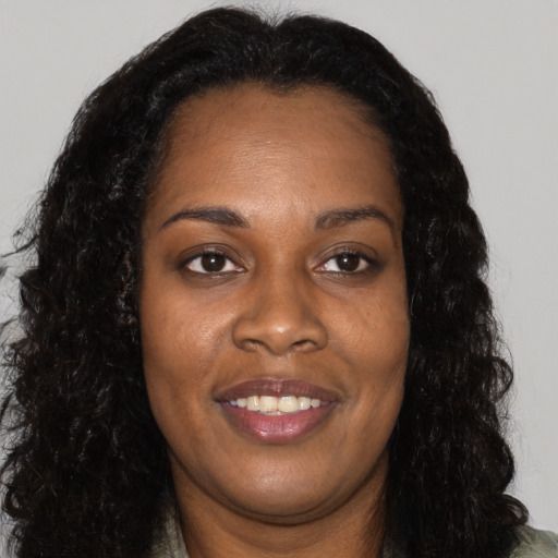 Joyful black adult female with long  black hair and brown eyes