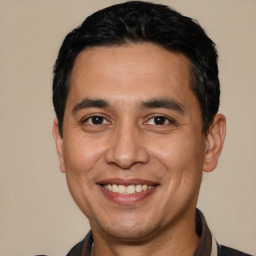 Joyful white adult male with short  black hair and brown eyes
