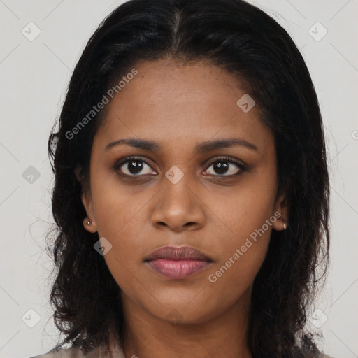 Joyful black young-adult female with long  black hair and brown eyes