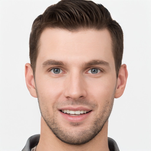 Joyful white young-adult male with short  brown hair and grey eyes