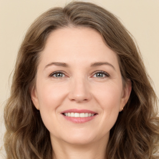 Joyful white young-adult female with long  brown hair and green eyes