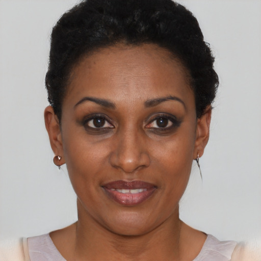 Joyful black young-adult female with short  black hair and brown eyes