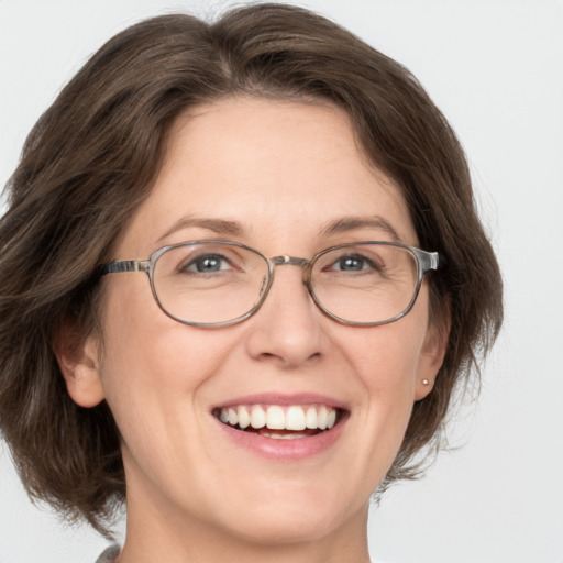 Joyful white adult female with medium  brown hair and green eyes