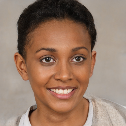 Joyful black young-adult female with short  brown hair and brown eyes