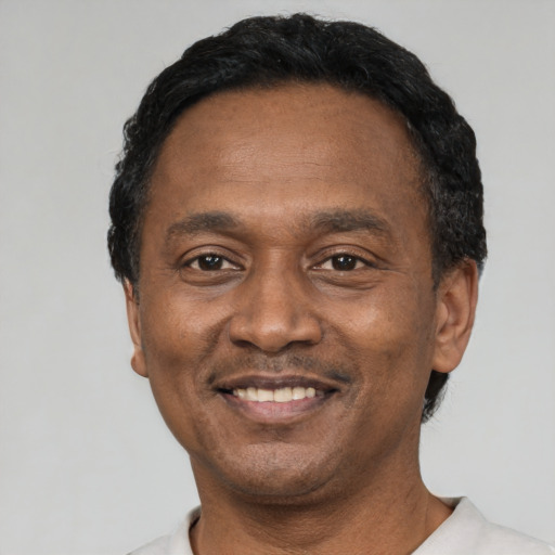 Joyful black adult male with short  black hair and brown eyes