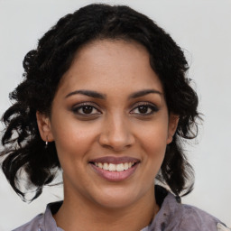 Joyful black young-adult female with long  brown hair and brown eyes