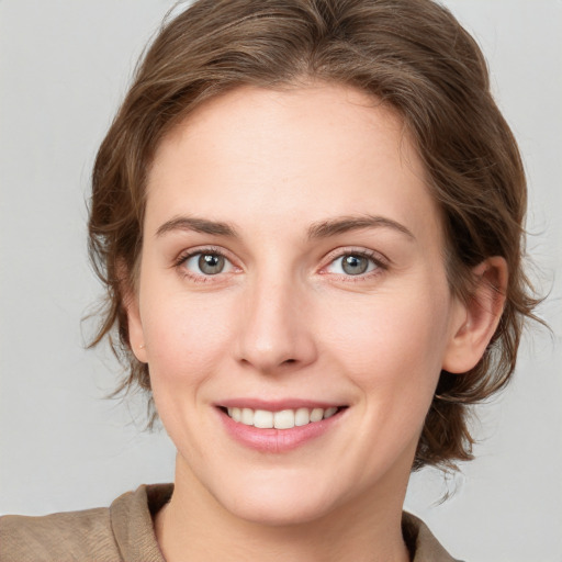 Joyful white young-adult female with medium  brown hair and grey eyes