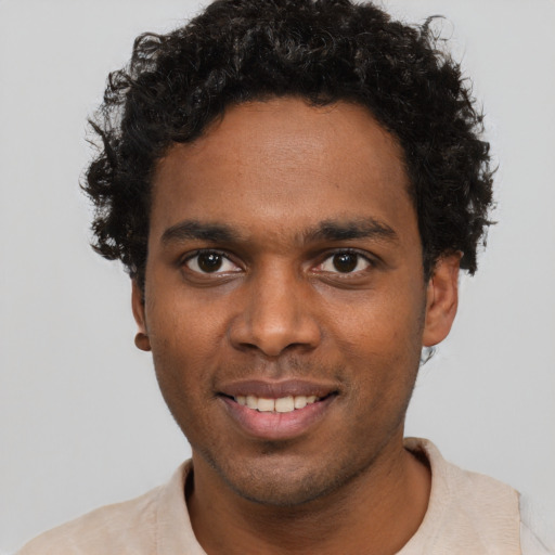 Joyful black young-adult male with short  brown hair and brown eyes
