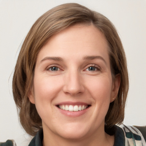 Joyful white young-adult female with medium  brown hair and green eyes