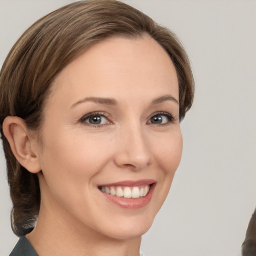 Joyful white young-adult female with medium  brown hair and brown eyes