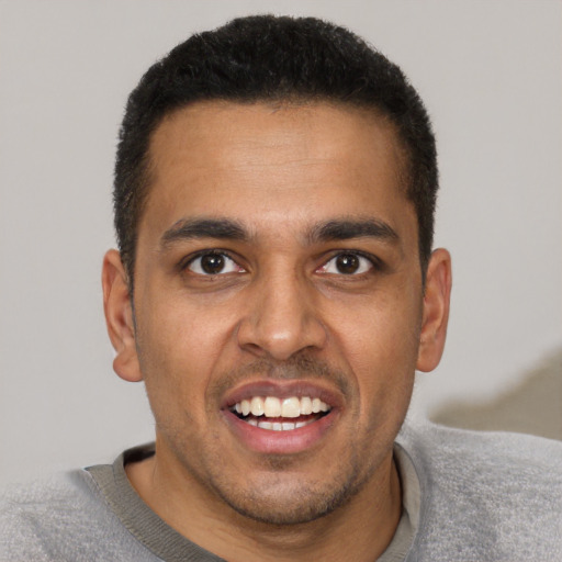 Joyful black young-adult male with short  brown hair and brown eyes