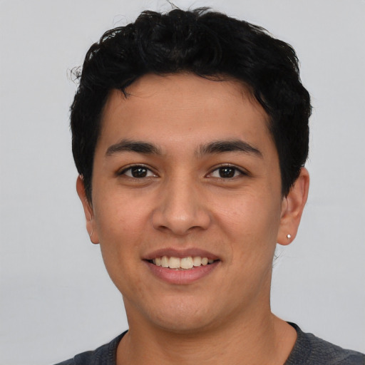 Joyful latino young-adult male with short  black hair and brown eyes