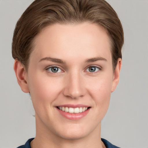 Joyful white young-adult female with short  brown hair and grey eyes