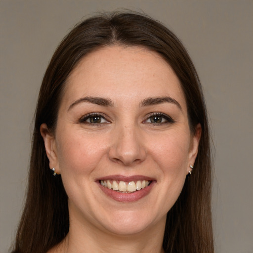 Joyful white young-adult female with long  brown hair and brown eyes