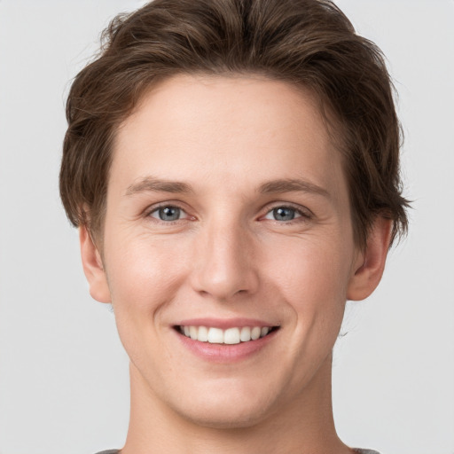 Joyful white young-adult female with short  brown hair and grey eyes