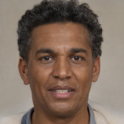 Joyful black adult male with short  black hair and brown eyes