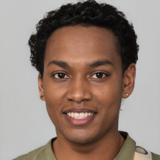 Joyful black young-adult male with short  black hair and brown eyes