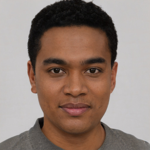 Joyful black young-adult male with short  black hair and brown eyes