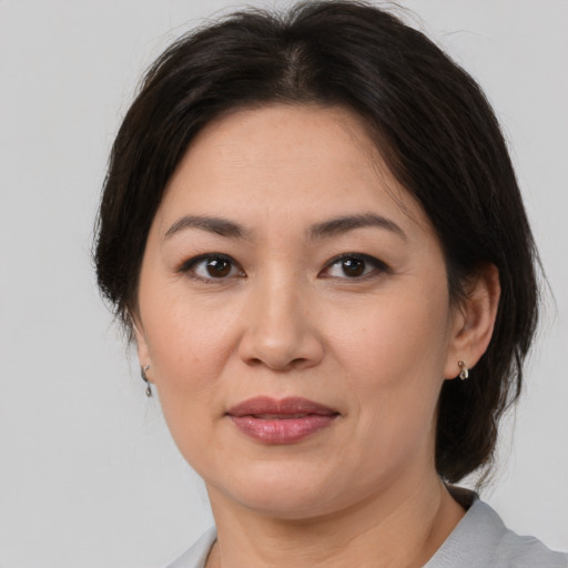 Joyful white adult female with medium  brown hair and brown eyes