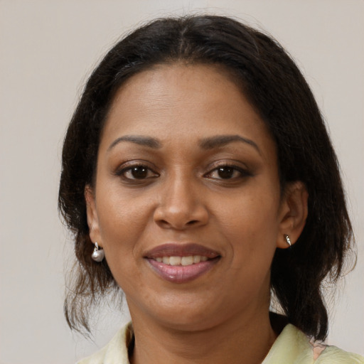 Joyful black adult female with medium  brown hair and brown eyes