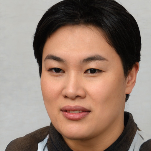 Joyful asian young-adult female with short  brown hair and brown eyes