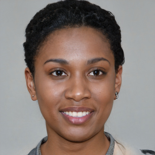 Joyful black young-adult female with short  black hair and brown eyes