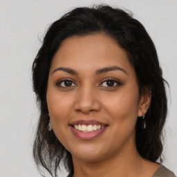 Joyful latino young-adult female with medium  brown hair and brown eyes