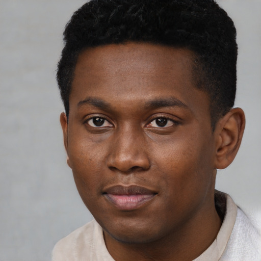 Joyful black young-adult male with short  brown hair and brown eyes