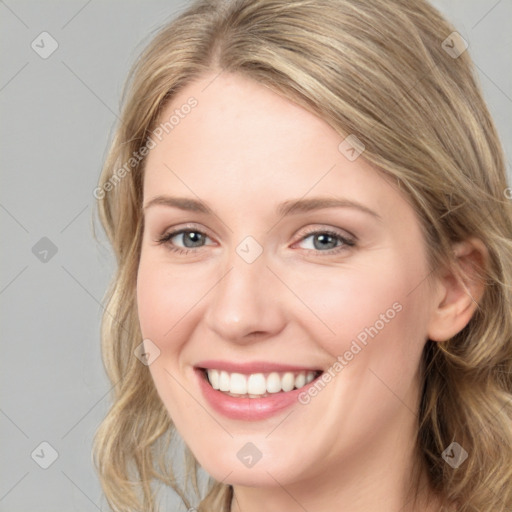 Joyful white young-adult female with long  brown hair and blue eyes