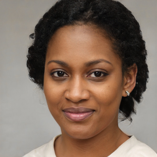 Joyful black young-adult female with medium  black hair and brown eyes