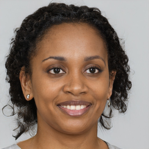 Joyful black young-adult female with medium  brown hair and brown eyes