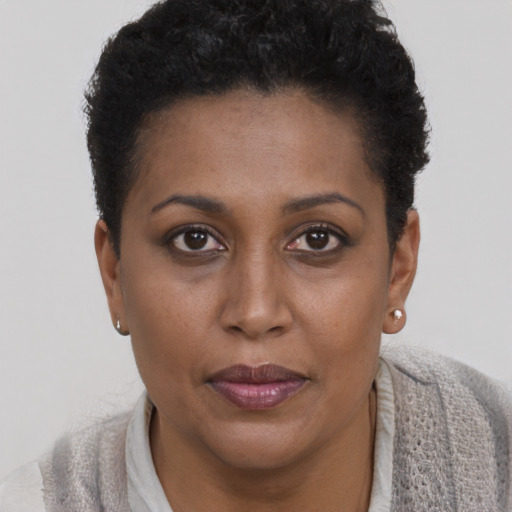 Joyful black young-adult female with short  brown hair and brown eyes