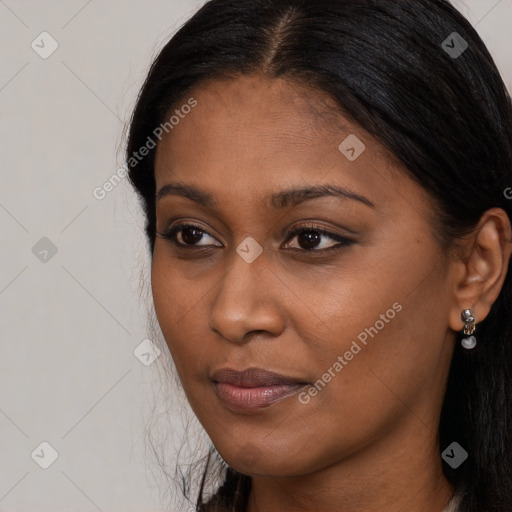 Joyful black young-adult female with long  brown hair and brown eyes