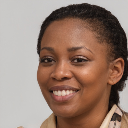 Joyful black young-adult female with medium  brown hair and brown eyes