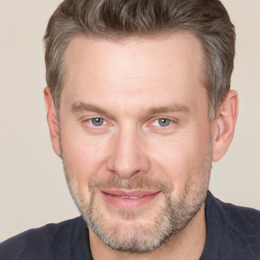 Joyful white adult male with short  brown hair and brown eyes