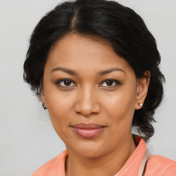 Joyful latino adult female with medium  brown hair and brown eyes